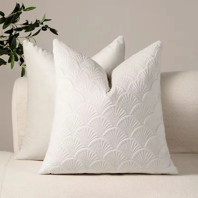 Weißes Kissen in Samtoptik mit Fächermuster vor einem hellen Sofa