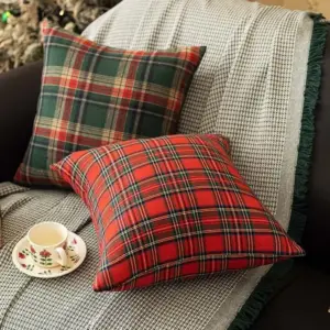 Zwei Kissenhüllen mit rotem und grünem Schottenkaro auf einem Sofa mit Decke