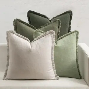 Kissenhüllen mit Fransenkante in Grün und Beige auf einem hellen Sofa