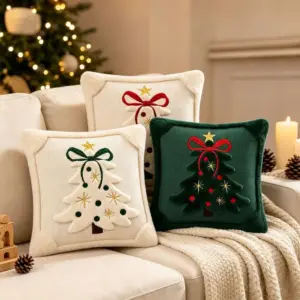 Drei Kissenbezüge mit Weihnachtsbaum-Motiv in Creme und Dunkelgrün auf einem Sofa