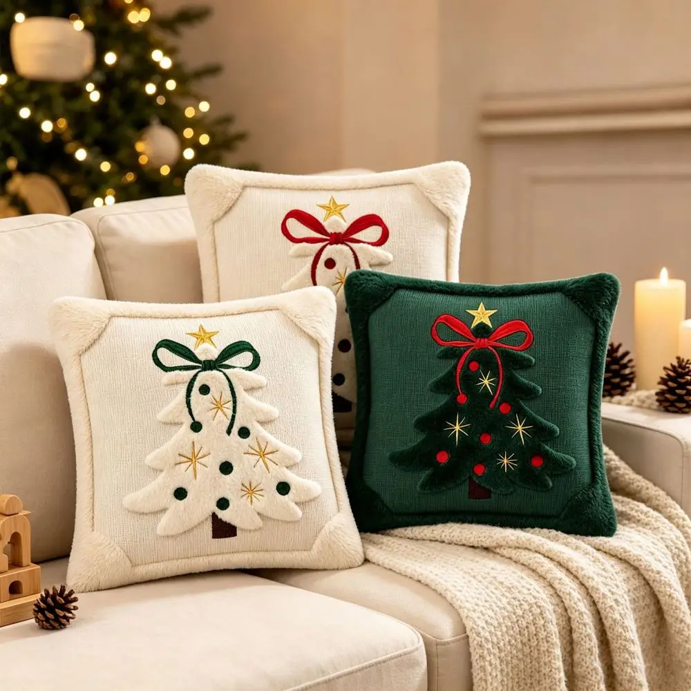 Drei Kissenbezüge mit Weihnachtsbaum-Motiv in Creme und Dunkelgrün auf einem Sofa