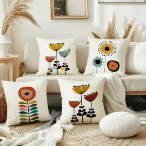 Vier Kissen mit bunten Blumenmotiven auf einem hellen Sofa im Wohnzimmer