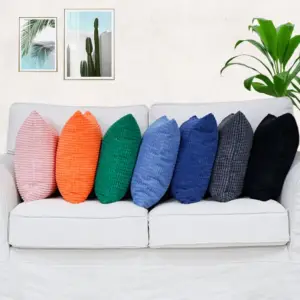 02-20 Bunte Kissenbezüge mit Würfelstruktur nebeneinander auf einem weißen Sofa