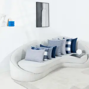 Blau-weiße Kissen mit Karo- und Streifenmuster auf einem hellen Sofa
