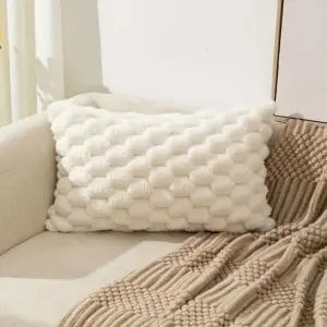 02-65 Cremeweiße Kissenhülle mit Wabenstruktur quer auf einem Sofa