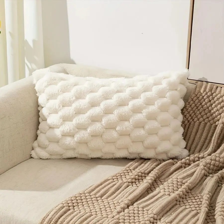 Cremeweiße Kissenhülle mit Wabenstruktur quer auf einem Sofa
