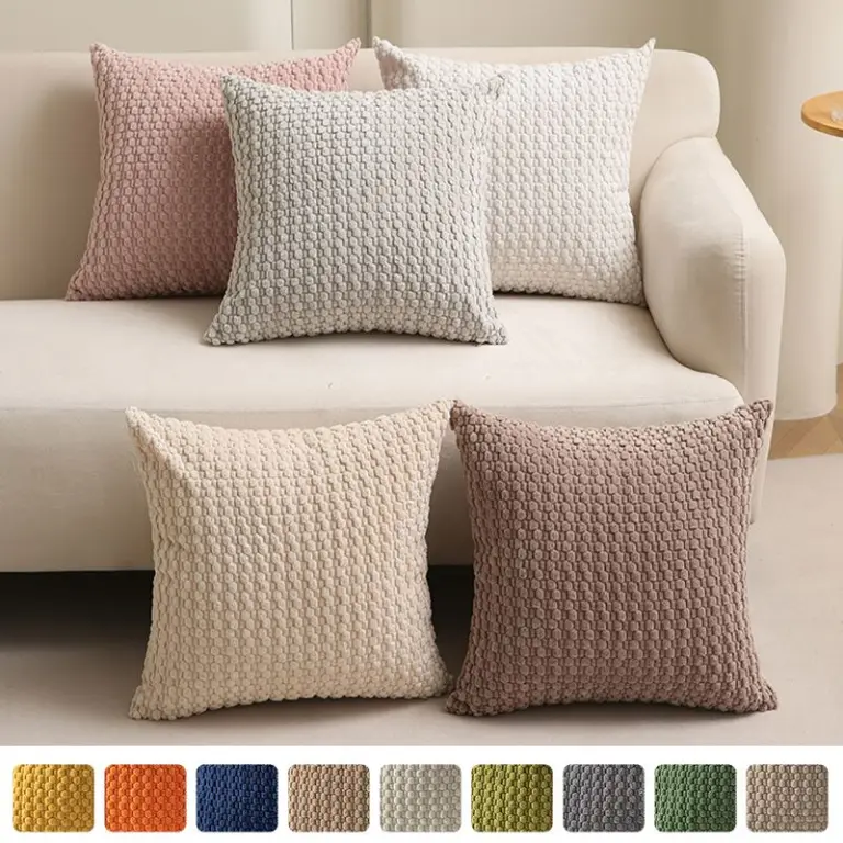 Fünf Kissenbezüge mit Waffelstruktur in Beige, Rosa und Creme auf einem Sofa